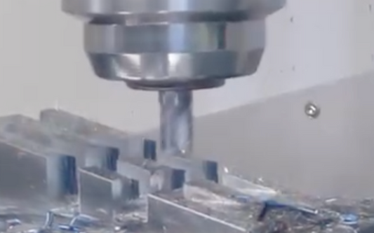 A CNC milling machine in action, precisely cutting a metal workpiece with coolant spray to ensure accuracy and reduce heat during the machining process.