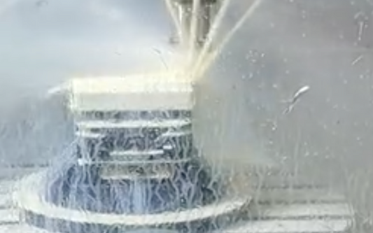 A CNC machine performing precision machining with a steady coolant spray, showcasing advanced milling capabilities for complex and large-scale parts.