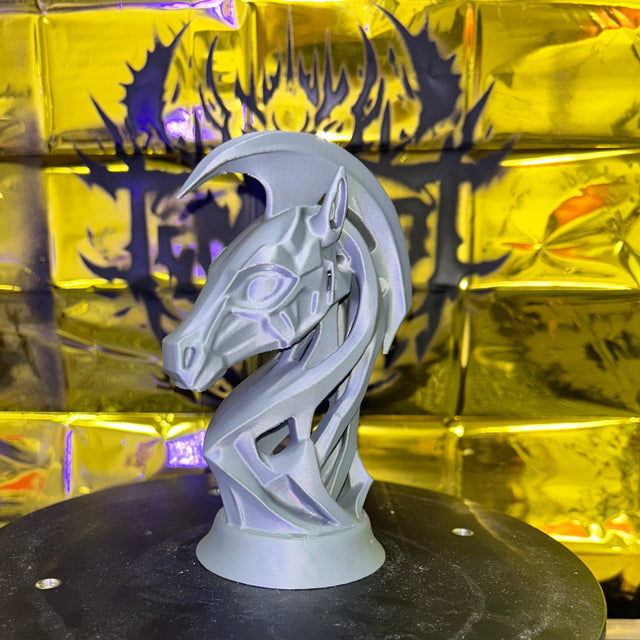 Side view of a 3D-printed, abstract robotic horse head sculpture with interwoven geometry and smooth finish, lit under yellow lighting.