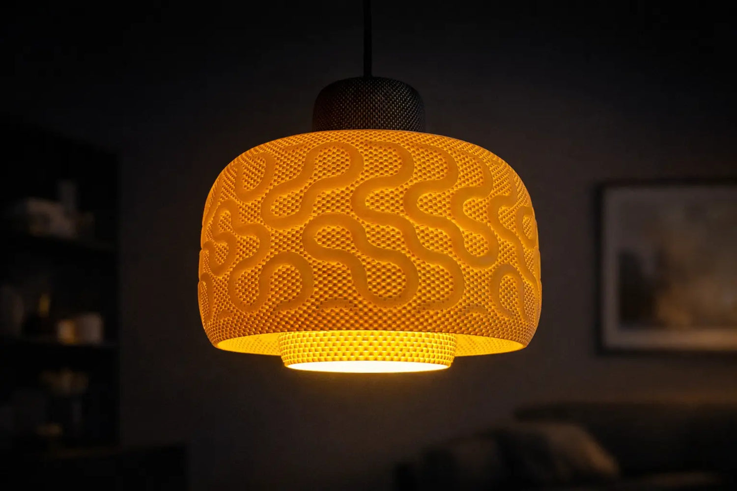Modern 3D printed pendant lamp with a textured sculptural shade glowing warm amber in a dark interior